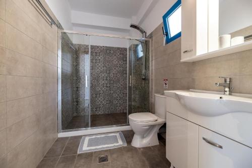 a bathroom with a shower and a toilet and a sink at Mikro Nisi Studios & Apartments in Agios Nikolaos