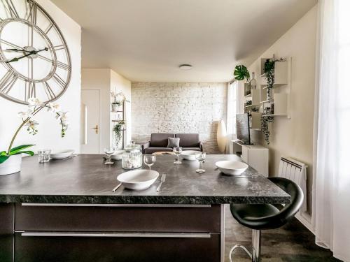 una cocina con un reloj grande en la pared en Appartement Le Petit Monde Magique, en Bailly-Romainvilliers