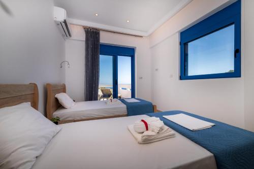 a bedroom with two beds and a window with a view at Mikro Nisi Studios & Apartments in Agios Nikolaos