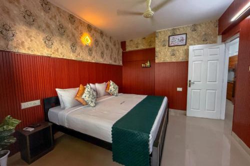 a bedroom with a large bed with red walls at Mayflower Family Lounge -Cochin Airport in Nedumbassery