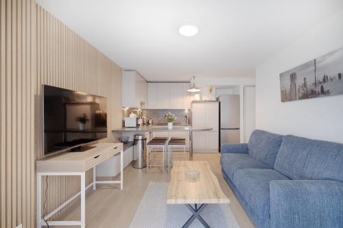 un salon avec un canapé bleu et une cuisine dans l'établissement 6 couchages Juan Les Pins Centre 22 Louis Gallet, à Juan-les-Pins