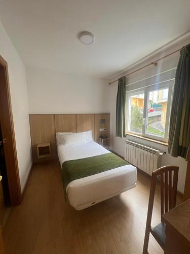 a small bedroom with a bed and a window at Hotel Crisol de las Rías in Miño