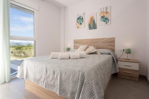 a bedroom with a bed with two towels on it at AT Gregal II in Oliva