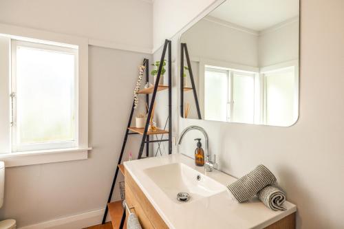 ein Badezimmer mit Waschbecken und Spiegel in der Unterkunft Hideaway Cottage in Oneroa