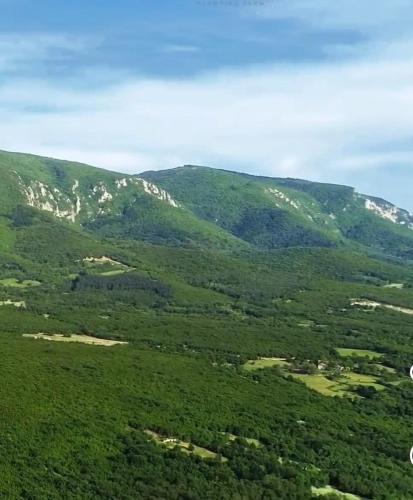 an aerial view of a green valley with mountains at DuVa mongolska yurta in Bistrica