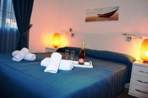 ein Hotelzimmer mit einem blauen Bett und einer Flasche Champagner in der Unterkunft Arona 1 - 3208 in Mar de Cristal