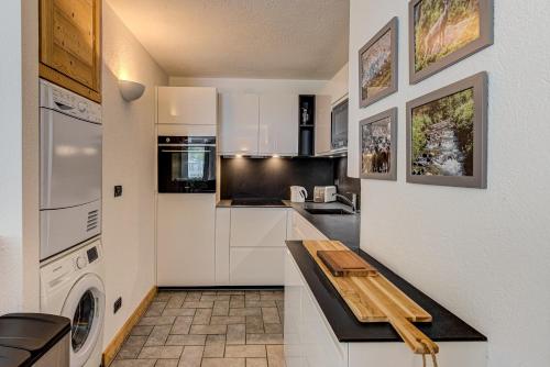 une cuisine avec des armoires blanches et un comptoir en bois dans l'établissement Apartment Winn, Alpes Travel, Central Chamonix, Sleeps 6, à Chamonix-Mont-Blanc
