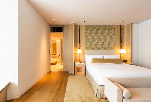 a bedroom with a large white bed and a hallway at Waldorf Astoria Bangkok in Bangkok