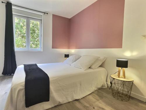 a bedroom with a white bed and a window at Le thannaron - Centre ville in Bourg-lès-Valence