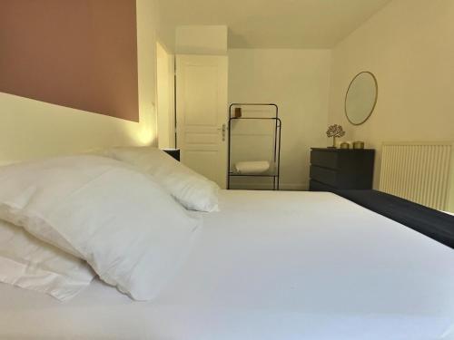 a bedroom with a large white bed and a chair at Le thannaron - Centre ville in Bourg-lès-Valence