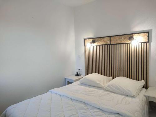 une chambre avec un lit blanc avec deux oreillers dans l'établissement Ref 066 A louer pour les vacances T3 pour 4 personnes avec piscine, à Arzon