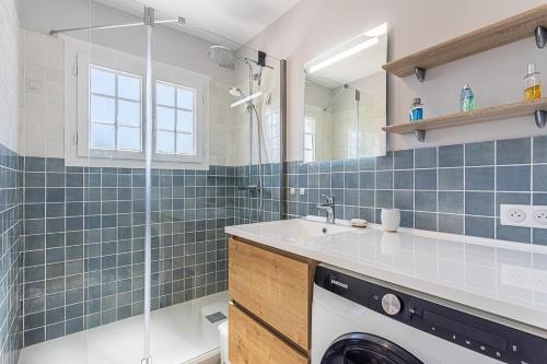 a bathroom with a washer and dryer next to a shower at Beau Rivage - 7min à pied de la Plage in Carqueiranne