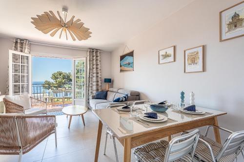 un salon avec une table et des chaises dans l'établissement Beau Rivage - 7min à pied de la Plage, à Carqueiranne