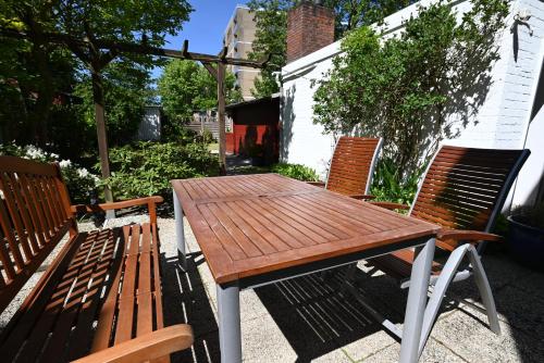 a wooden table and two chairs sitting next to a table and benches at Strandhotel Salty in Büsum