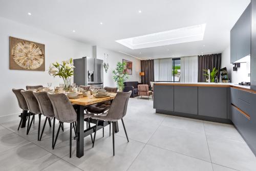 a kitchen and dining room with a table and chairs at Spacious Parking Stylish 5BR 7 Beds Sleeps 11 Free Parking And Wifi in Luton