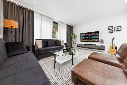 a living room with a couch and a table at Spacious Parking Stylish 5BR 7 Beds Sleeps 11 Free Parking And Wifi in Luton