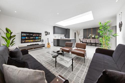 a living room with a couch and a table at Spacious Parking Stylish 5BR 7 Beds Sleeps 11 Free Parking And Wifi in Luton