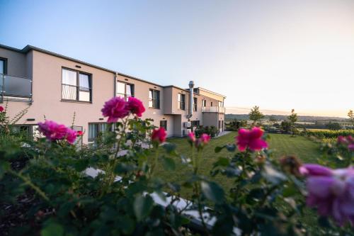 a row of houses with pink flowers in the foreground at Weinzuhause Hotel-Restaurant-Vinothek in Mommenheim