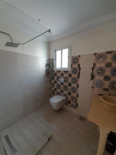 a bathroom with a toilet and a window at 120m2 House, Tunisia in Bin Rhilouf