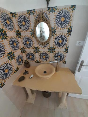 a bathroom with a sink and a mirror on a wall at 120m2 House, Tunisia in Bin Rhilouf