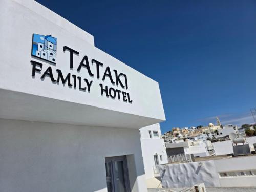 a sign for a tata family hotel on the side of a building at Tataki Family Hotel in Fira