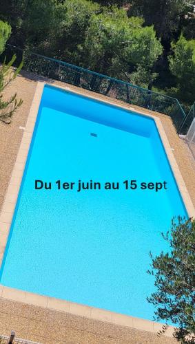une piscine bleue avec un panneau sur celle-ci dans l'établissement Appartement en résidence avec piscine, à Bandol