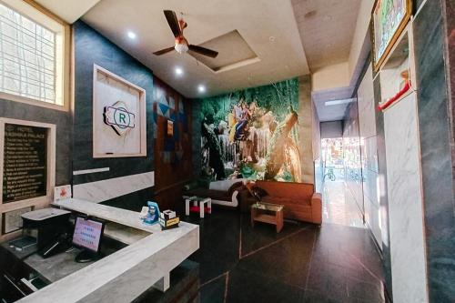 a living room with a painting on the wall at Hotel Rashika Palace Near Sindhi Camp Bus Stand, Jaipur in Jaipur