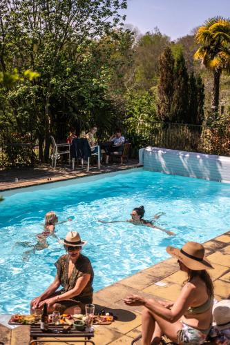 un groupe de personnes assises dans une piscine dans l'établissement Maison Tournesol Massages Pau Jurançon, à Gan
