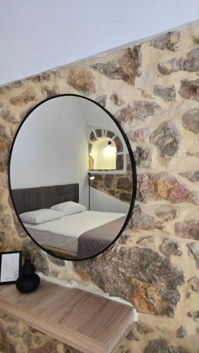a bedroom with a mirror on a stone wall at Lithino in Líthion