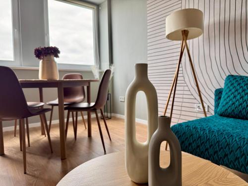 a living room with a table and two vases at Panorama View Deluxe Apartment in Veszprém