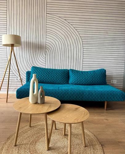 a living room with a blue couch and a table at Panorama View Deluxe Apartment in Veszprém