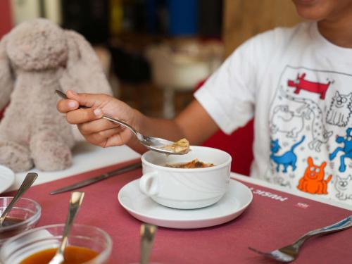 a person sitting at a table with a cup of food at Ibis Sfax in Sfax