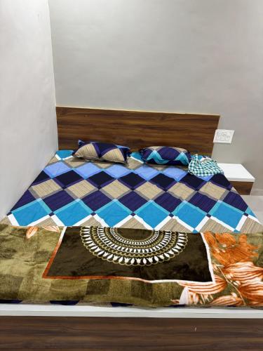 a bedroom with a bed with a checkerboard bedspread at Gurumauli Guesthouse in Akalkot