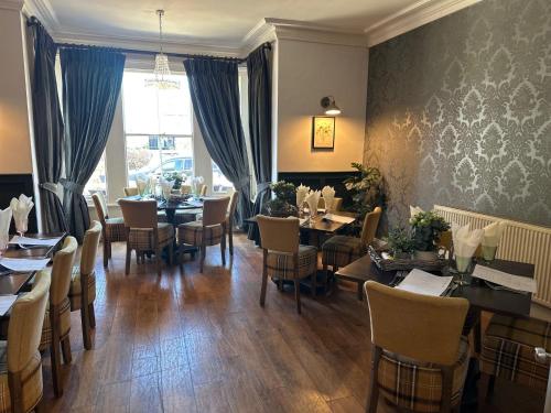 a dining room with tables and chairs and a window at Slepe Hall Hotel in St Ives