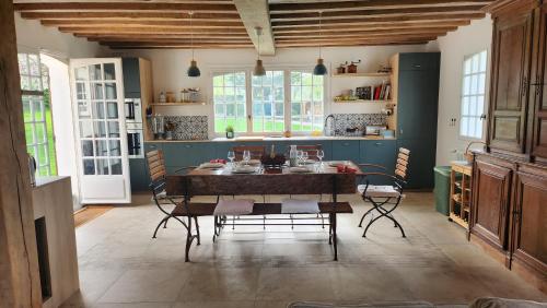 une salle à manger avec une table et des chaises dans l'établissement Les Vallons, à Gonneville-sur-Mer