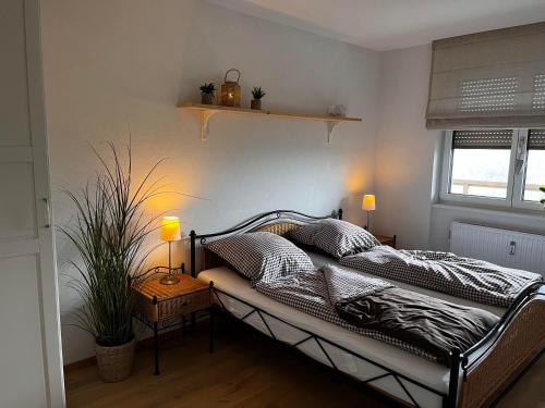 a bedroom with a bed with a lamp and a plant at Apartment Alpenblick am Urbansee in Sankt Urban