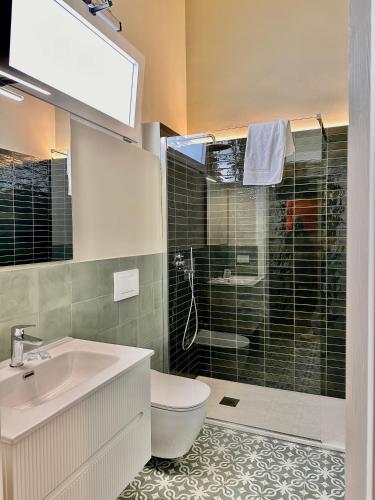 a bathroom with a toilet and a sink and a shower at Dimora Aquae Suites&Spa in Mola di Bari