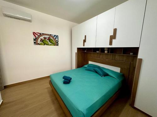 a bedroom with a bed with blue pillows on it at Domus Apartament in Capo dʼOrlando