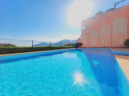une grande piscine bleue à côté d'un immeuble dans l'établissement Magnifique 2p vue mer et piscine, à Théoule-sur-Mer