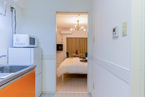 与那原町オーシャンビュー 窓から見える景色を想い出に The琉球タワー 10C的厨房设有通往卧室的门