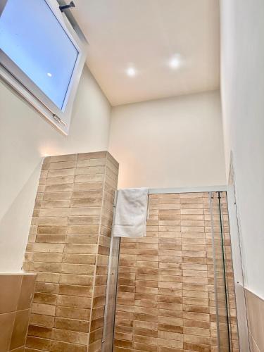 a bathroom with a skylight and a wooden floor at Dimora Aquae Suites&Spa in Mola di Bari