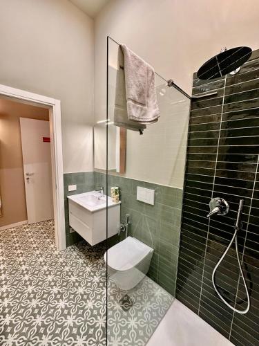 a bathroom with a shower and a toilet and a sink at Dimora Aquae Suites&Spa in Mola di Bari