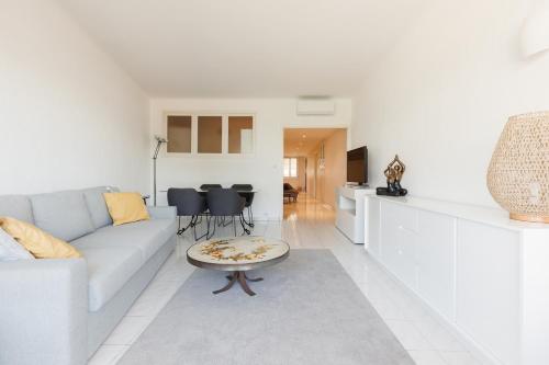 un salon blanc avec un canapé et une table dans l'établissement Cannes: Croisette Quartier Martinez - 90m², à Cannes