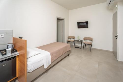 a bedroom with a bed and a table and chairs at Emi Seaside in Amoudara Herakliou