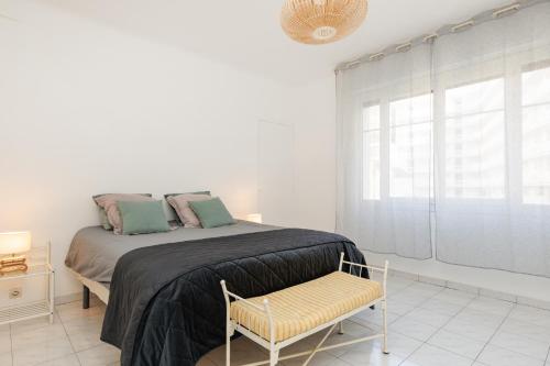une chambre avec un lit avec une chaise et une fenêtre dans l'établissement Cannes: Croisette Quartier Martinez - 90m², à Cannes
