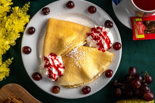 a plate of pancakes with cherries and a cup of coffee at U Musa in Karpacz