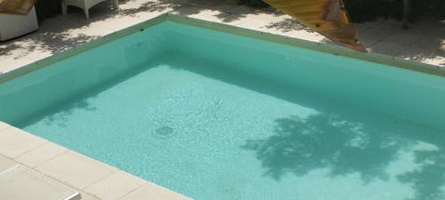 a large pool of blue water in a yard at Dimora Maltese in Morciano di Leuca