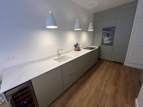 une cuisine blanche avec un évier et une cuisinière dans l'établissement GuestReady - Luxurious Charm near Arc de Triomphe, à Paris