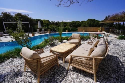 a group of chairs and tables next to a pool at Cumbalıca Flora in Cesme