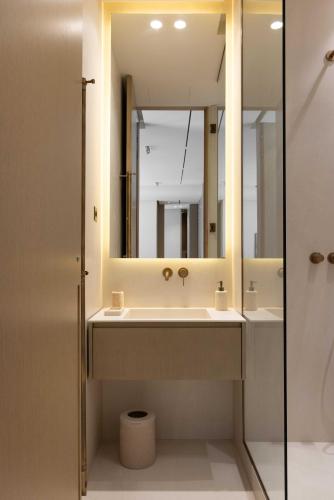une salle de bain avec un lavabo et un miroir dans l'établissement Luxurious Residence Madeleine - Saint Honore, à Paris